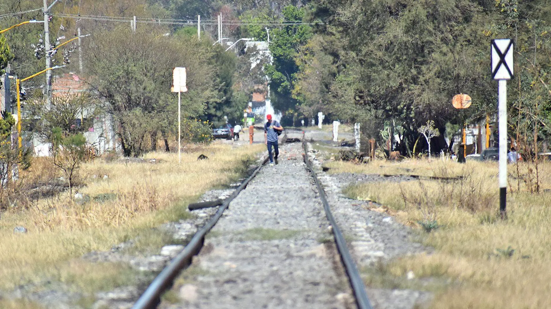 persona camina en vias de tren